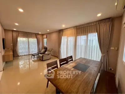 Spacious living room with elegant dining area and large windows for natural light.