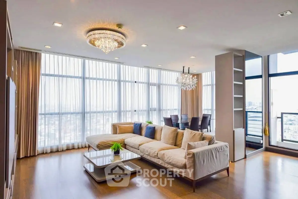 Luxurious corner unit living room with panoramic city views and elegant chandeliers.