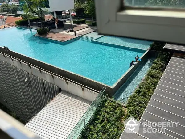 Luxurious residential complex with a sparkling outdoor pool and well-maintained wooden deck area, offering a serene urban oasis for relaxation and leisure.