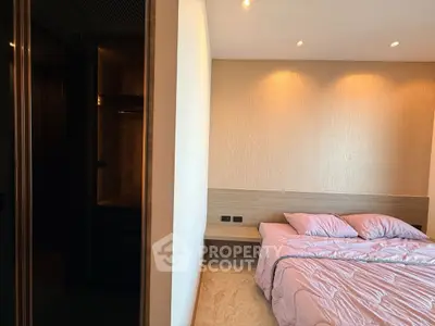 Modern bedroom with elegant lighting and cozy bedding in a stylish apartment.