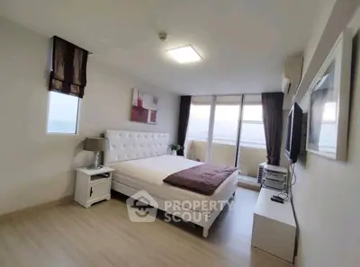 Spacious modern bedroom with large windows and stylish decor in a high-rise apartment.