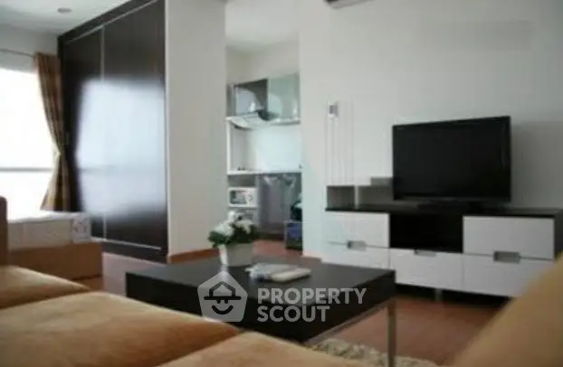 Modern living room with sleek furniture and open kitchen layout in a stylish apartment.