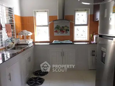 Modern kitchen with stainless steel appliances and bright orange backsplash