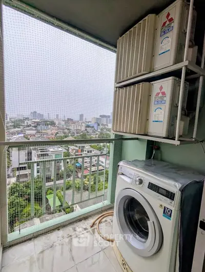 High-rise balcony with city view and laundry appliances, perfect for urban living.