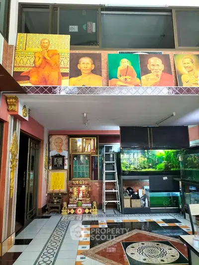 Spacious interior with religious decor and large fish tanks, ideal for meditation or relaxation.