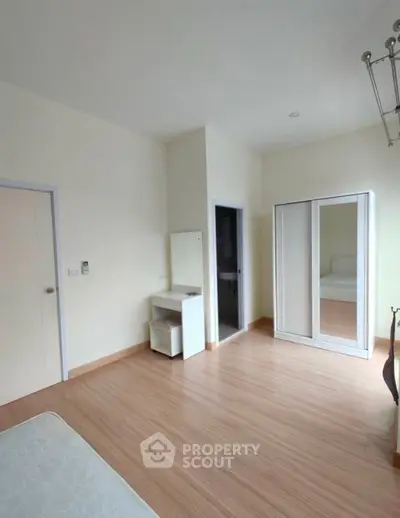 Spacious bedroom with modern wardrobe and vanity in minimalist style.