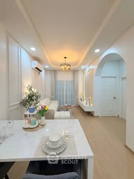 Elegant living room with modern decor and cozy ambiance, featuring a stylish dining area and soft lighting.