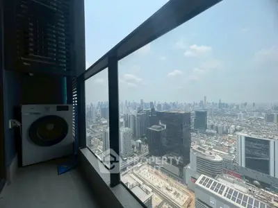Stunning high-rise balcony view with cityscape and washing machine, perfect urban living.