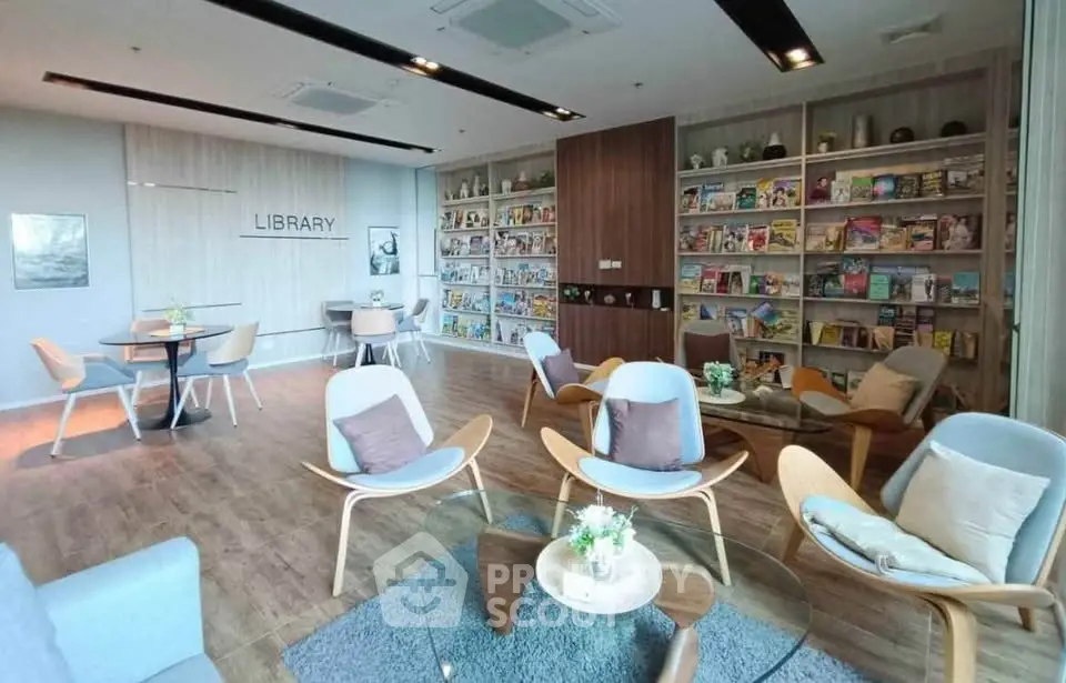 Modern library with stylish seating and extensive book collection in a real estate property.