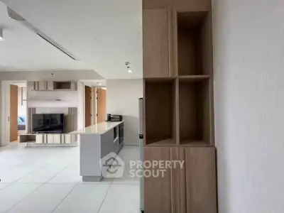 Modern open-plan living room with sleek kitchen island and built-in TV unit