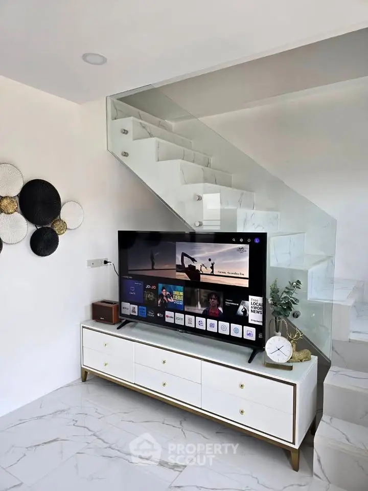 Modern living room with sleek TV unit and stylish staircase