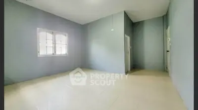 Spacious empty room with tiled flooring and large window, perfect for customization.