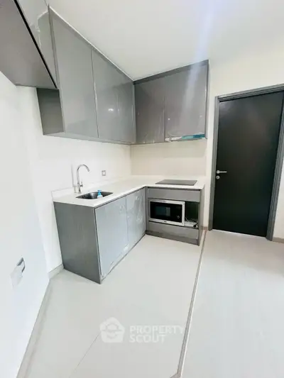 Modern kitchen with sleek cabinetry and built-in appliances in a compact layout.