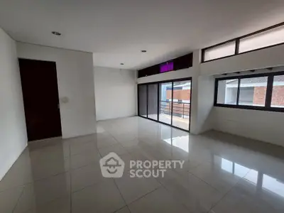 Spacious modern living room with large windows and balcony access