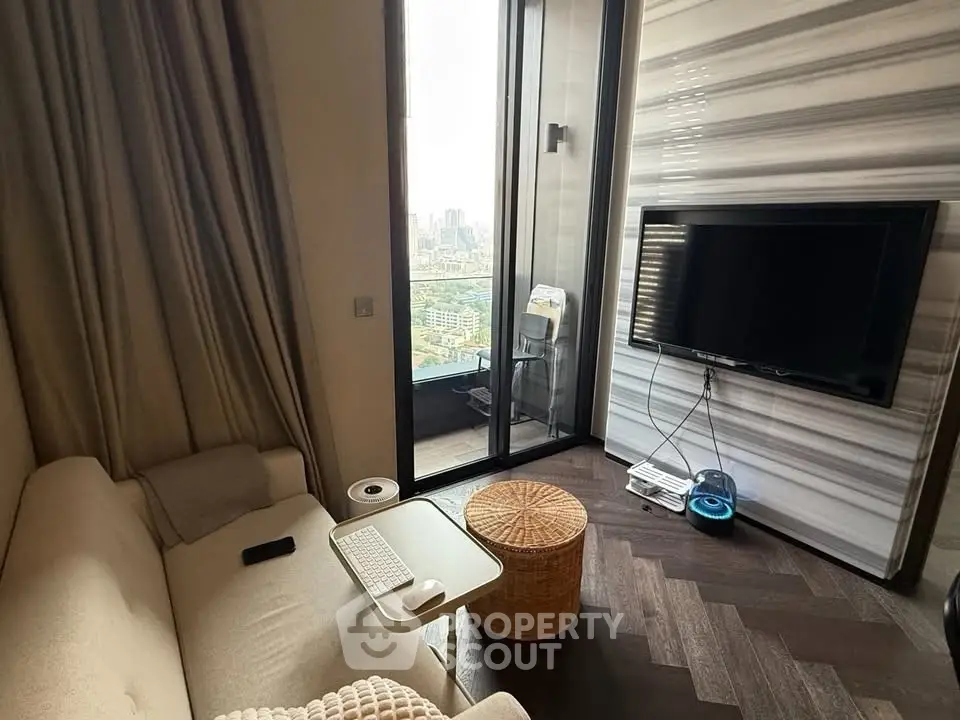 Modern living room with city view, cozy seating, and sleek TV setup.