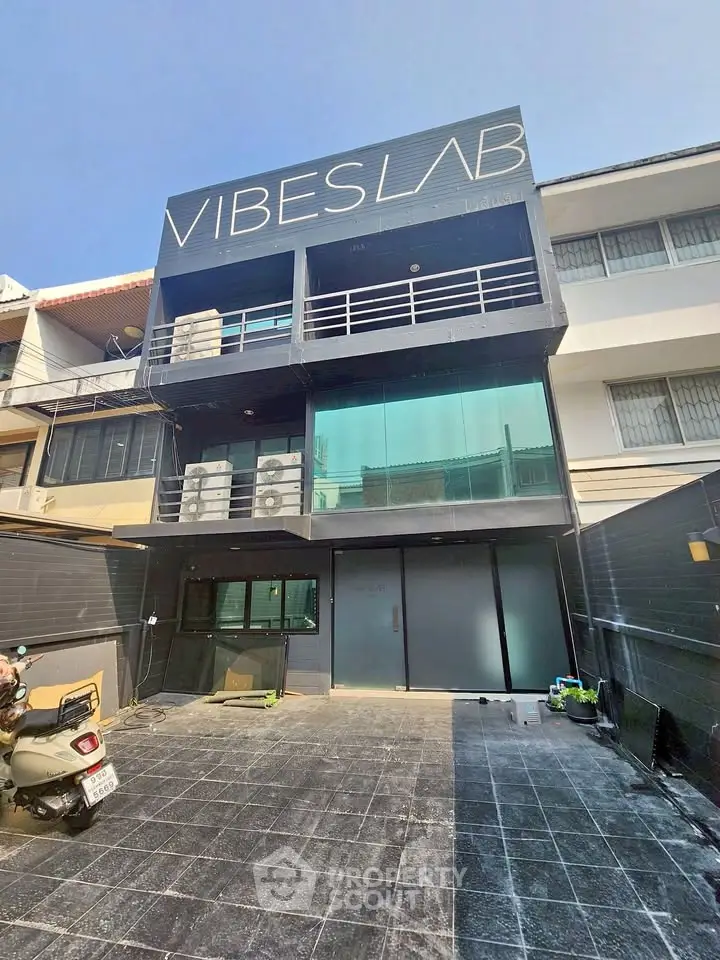 Modern commercial building with sleek glass facade and spacious balcony, ideal for business opportunities.