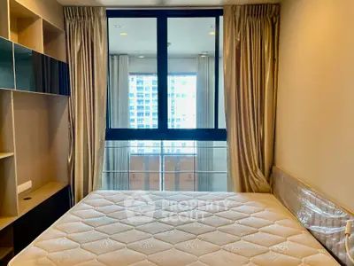 Modern bedroom with large window and city view, featuring elegant curtains and built-in shelving.