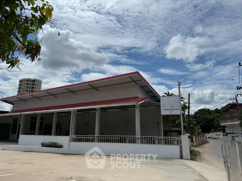 Spacious commercial building with ample parking and modern design under a vibrant sky.