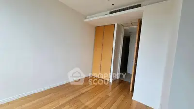 Spacious empty bedroom with wooden flooring and built-in closet