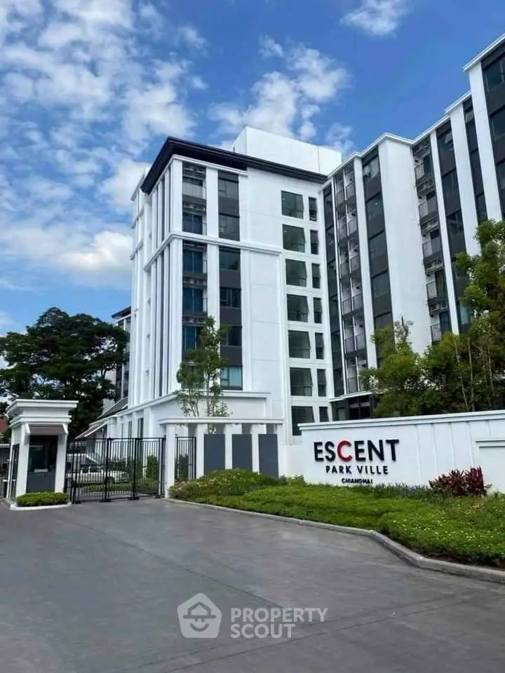 Modern residential building with lush greenery and clear blue sky at Escent Park Ville.