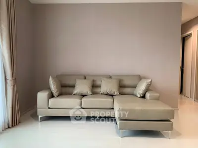 Modern living room with elegant beige sectional sofa and soft lighting