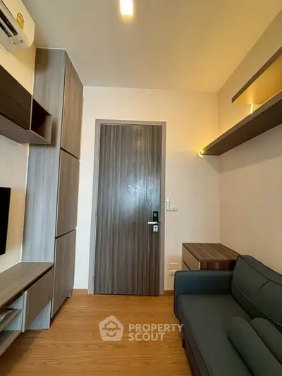 Modern living room with sleek wooden door and stylish furniture in a cozy apartment.
