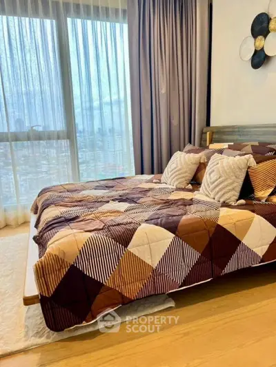 Cozy bedroom with stylish decor and large window offering city views.