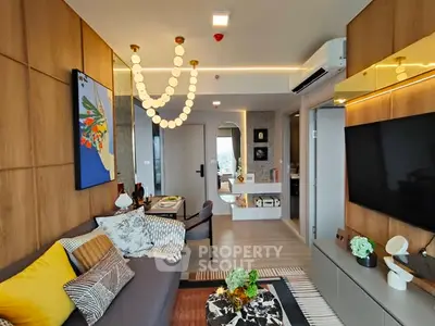 Modern living room with stylish decor and open layout, featuring a cozy sofa and elegant lighting.