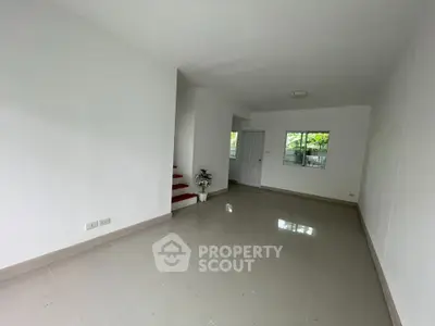 Spacious living room with glossy tiled floors and natural light, perfect for modern living.