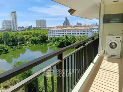 Spacious balcony with scenic city and lake view, featuring a washing machine for convenience.