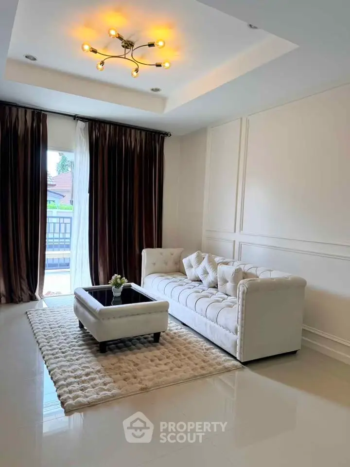 Elegant living room with plush white sofa, stylish lighting, and luxurious decor.