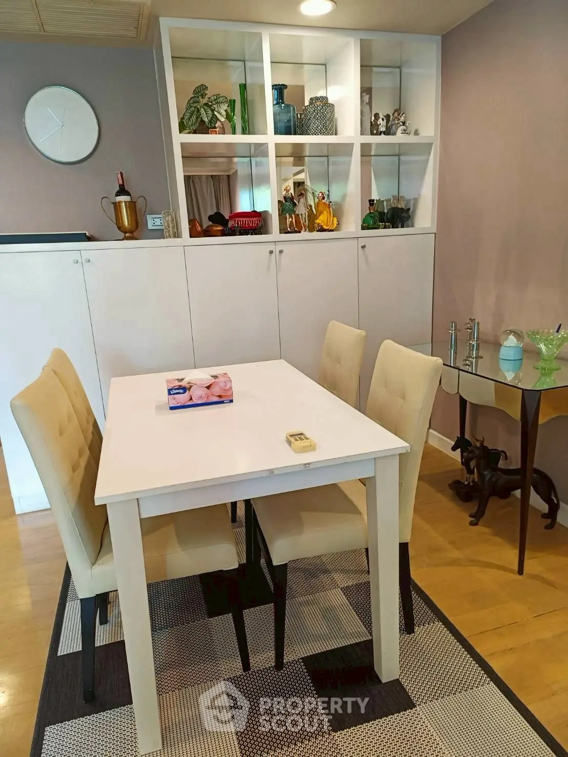 Chic dining area with modern decor and elegant shelving in a stylish apartment.