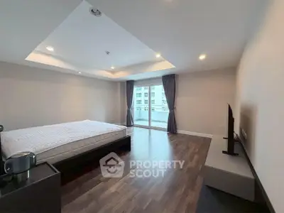 Spacious modern bedroom with large window and sleek flooring