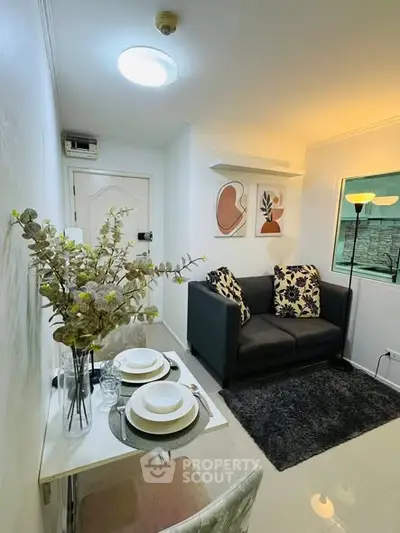 Cozy living room with modern decor and dining area in a compact apartment.
