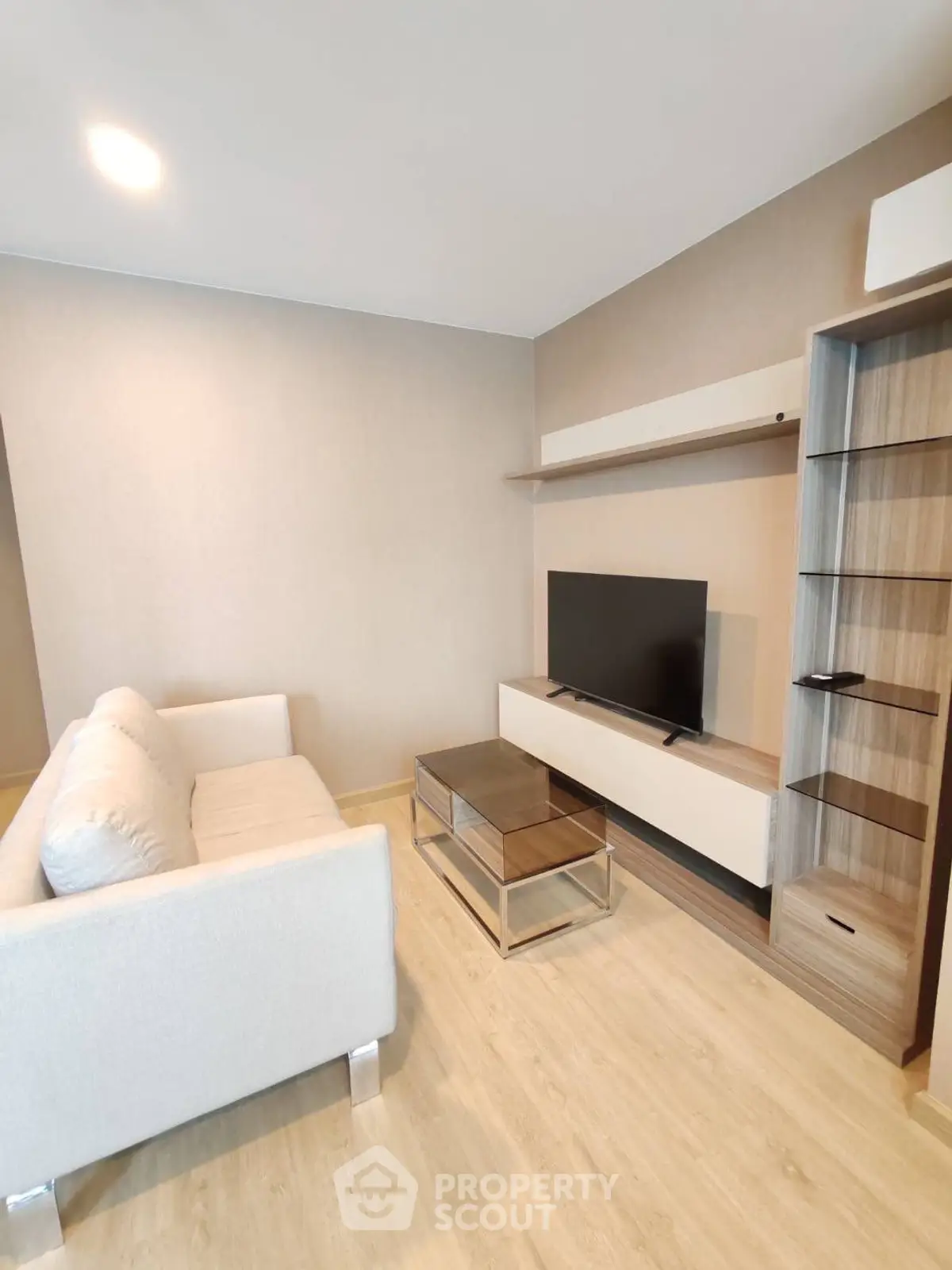 Modern living room with sleek furniture and flat-screen TV, perfect for relaxation.