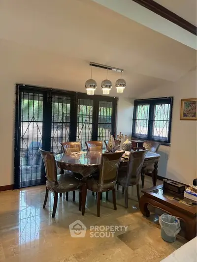 Elegant dining room with stylish lighting and large windows, perfect for family gatherings.