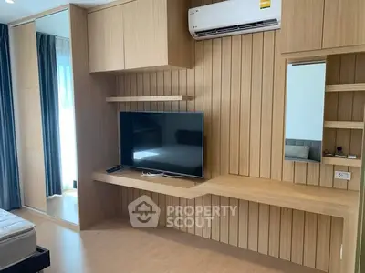 Modern bedroom with wooden paneling, wall-mounted TV, and air conditioning unit.