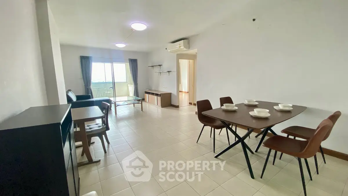Spacious living room with dining area and modern furniture in a bright apartment.