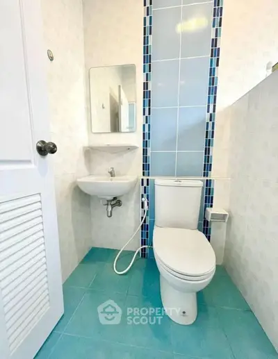 Modern bathroom with blue tiles and compact design