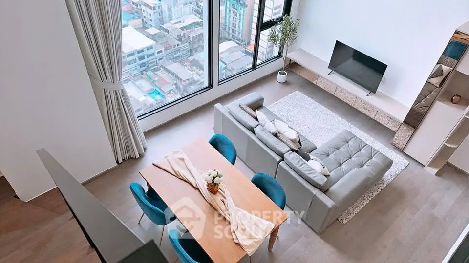 Modern living room with large windows and city view, featuring stylish furniture and elegant decor.