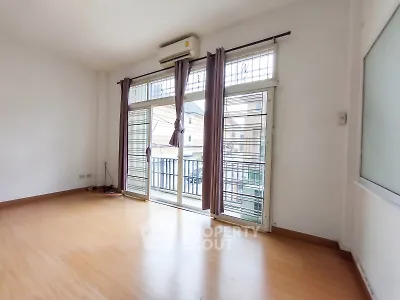 Spacious empty room with large windows and balcony access, perfect for customization.
