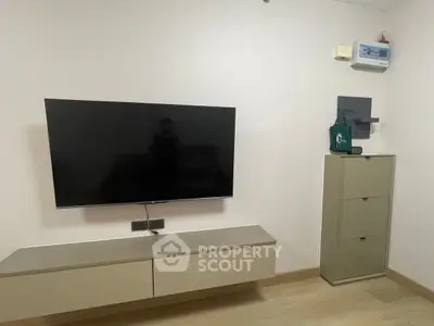 Modern minimalist living room with wall-mounted TV and sleek storage unit.