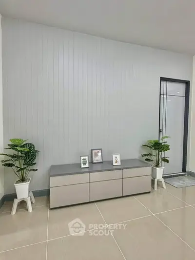 Modern minimalist interior with sleek console table and potted plants, perfect for stylish living room decor.