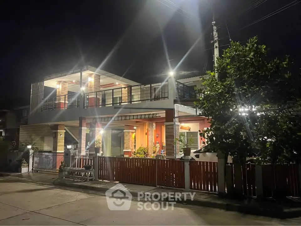 Stunning two-story modern home with bright exterior lighting and spacious balcony, perfect for family living.