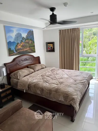 Spacious bedroom with elegant decor and large window view