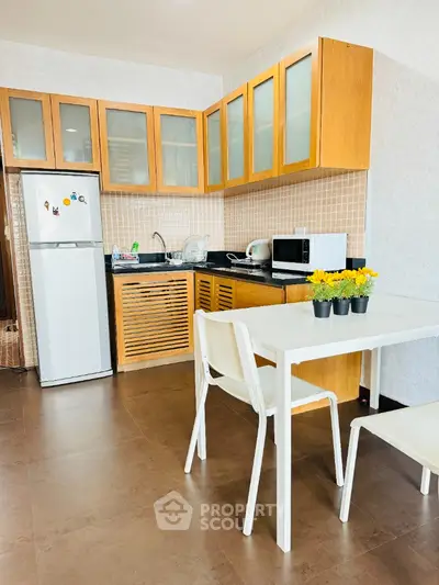Modern kitchen with wooden cabinets and dining area in cozy apartment