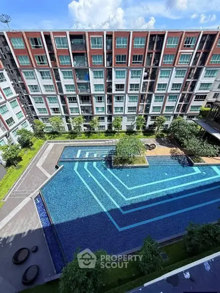 Modern apartment complex with a stunning outdoor pool and lush greenery, perfect for urban living.