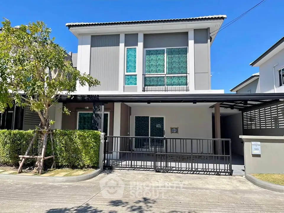 Modern two-story house with sleek design and spacious driveway in a serene neighborhood.