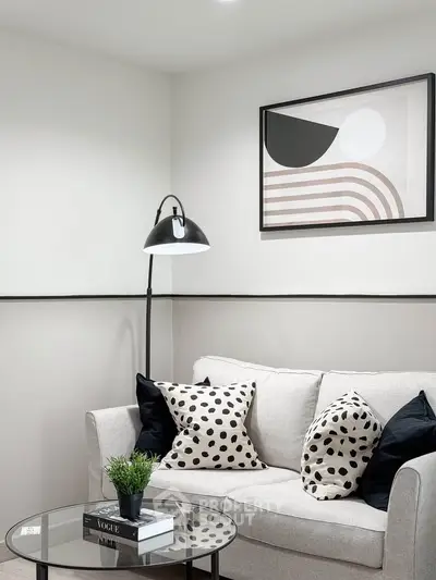 Stylish living room with modern decor, featuring a cozy sofa, chic artwork, and elegant lighting.