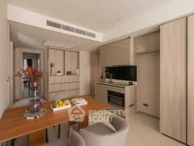 Modern kitchen with sleek cabinetry and dining area in stylish apartment.